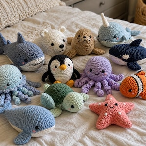 May include: A collection of eleven handmade crochet plush toys featuring various sea creatures and arctic animals, including a shark, polar bear, seal, narwhal, orca, jellyfish, penguin, octopus, clownfish, sea turtle, whale, and a starfish.