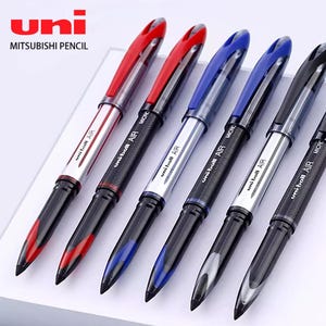 May include: A set of six Uni-ball AIR Micro pens arranged in a row. The pens feature a mix of red, blue, and black ink colors with clear and colored plastic barrels. Each pen is labeled with the text Uni-ball AIR and Micro on the barrel.