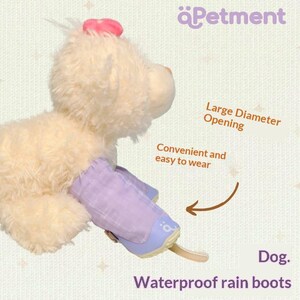 May include: A cream-colored plush toy dog wearing a light purple waterproof rain boot on one paw. The boot features a large diameter opening and a strap. Text on the image includes "Petment", "Large Diameter Opening", "Convenient and easy to wear", "Dog.", and "Waterproof rain boots".