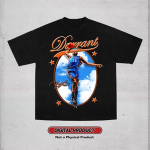 May include: A black t-shirt featuring a graphic of a basketball player in a blue jersey with the number 35, jumping toward a basketball. The design includes the text "Durrant" in orange, a blue sky background, orange stars, and a signature.