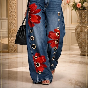 Könnte beinhalten: Weit geschnittene blaue Jeans aus Denim mit großen roten Blumenmustern und goldenen Metallösen an den Seitennähten. Die Hose hat eine hohe Taille mit Knopfverschluss und ein klassisches Fünf-Taschen-Design, kombiniert mit einer schwarzen Handtasche.