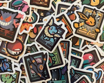 May include: A collection of die-cut stickers featuring various colorful cartoon creatures depicted in a trading card style. Each sticker shows a unique character framed within a rectangular border with bold black outlines and vibrant graphic details.