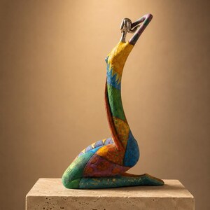 May include: A stylized sculpture of a kneeling figure with an elongated torso and arms raised above the head. The surface features a vibrant patchwork of yellow, green, blue, orange, and purple sections with varied textures and a metallic silver head.