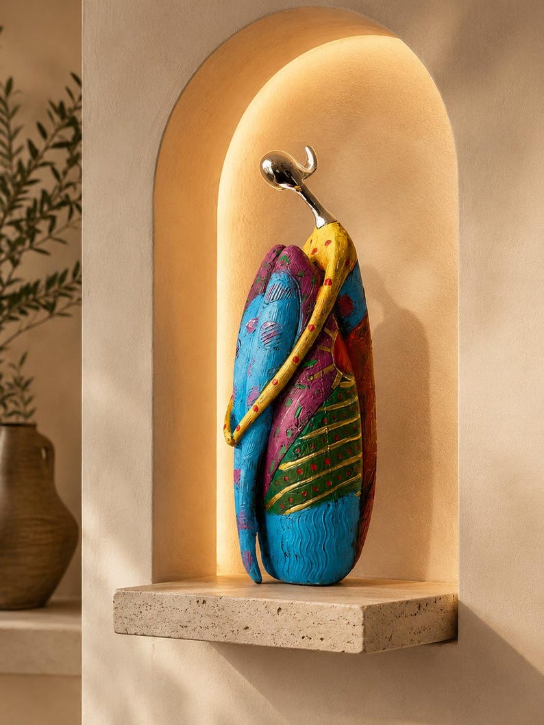 Puede incluir: Una escultura decorativa de una figura estilizada con cabeza y cuello de color plata liso. El cuerpo est&aacute; pintado en secciones vibrantes de azul, amarillo, magenta y verde, con patrones texturizados que incluyen l&iacute;neas onduladas y puntos.