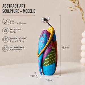 Puede incluir: Una escultura de arte abstracto, modelo B, con una figura estilizada de cabeza plateada y cuerpo colorido. La escultura mide 8,5 x 7 x 23,4 cm y tiene un peso neto de 0,32 kg. La superficie muestra patrones en azul, amarillo, morado y verde.