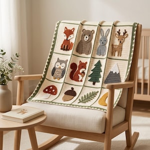 May include: A cream-colored crochet blanket featuring a grid pattern with various woodland-themed appliques, including a fox, bear, rabbit, deer, owl, squirrel, pine tree, mountain, mushroom, acorn, fern leaf, and a crescent moon shape.