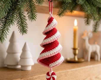 Puede incluir: Un adorno para árbol de Navidad en forma de espiral hecho de hilo de ganchillo rojo y blanco. El adorno presenta un patrón de colores inspirado en los bastones de caramelo y cuelga de un pequeño lazo. Un disco redondo de ganchillo rojo y blanco cuelga en la parte inferior.