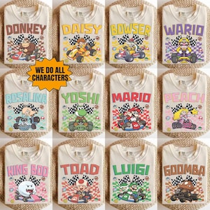 Pode incluir: Uma coleção de doze camisetas off-white com vários personagens da Nintendo em karts, incluindo Donkey, Daisy, Bowser, Wario, Rosalina, Yoshi, Mario, Peach, King Boo, Toad, Luigi e Goomba, com o texto WE DO ALL CHARACTERS.