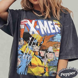 May include: A charcoal gray short-sleeve t-shirt featuring a vintage-style Marvel Comics X-Men graphic print on the front. The design displays Wolverine with extended claws alongside other X-Men characters, with the bold text X-MEN at the top.