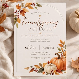 May include: A Friendsgiving potluck invitation card featuring an arched border, watercolor autumn leaves, red berries, and two pumpkins. The text reads: You're invited to a Friendsgiving Potluck, Good Food, Great Company, Grateful Hearts, Sat Nov 21 at 5:00 PM.