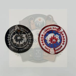 Può includere: Due toppe ricamate circolari con il testo Canada Goose Arctic Program. Una toppa è nera con ricamo bianco, l'altra è bianca con bordo rosso, cerchio interno blu e dettagli ricamati in rosso e bianco.