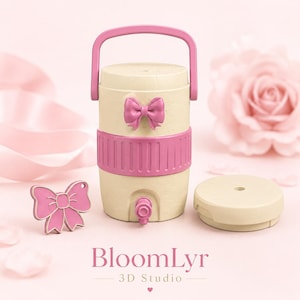 Puede incluir: Un dispensador de bebidas beige con asa rosa, banda central rosa y un lazo rosa en la parte frontal. Incluye un pequeño grifo en la base, una tapa beige separada y un dije de lazo rosa suelto. El texto BloomLyr 3D Studio es visible.