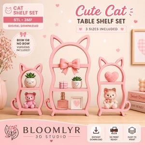 May include: A set of three pink cat-shaped table shelves in varying sizes, featuring cat ears and tails. The shelves are displayed with decorative items including small potted plants, a perfume bottle, a heart, and two small teddy bear figurines.