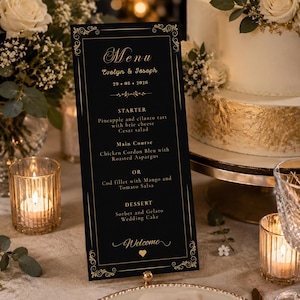 Peut inclure: Une carte de menu de mariage verticale noire avec du texte en feuille d'or et des bordures décoratives. Le texte indique Menu, Evelyn & Joseph, 29.08.2026, Starter, Main Course, Dessert et Welcome, avec un petit cœur doré en bas.
