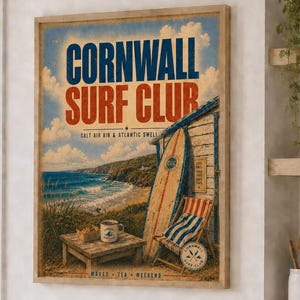 May include: A rectangular wall art print titled Cornwall Surf Club featuring a coastal scene with a wooden surf shack, a surfboard, a beach chair, and a small table with a mug. The text reads Cornwall Surf Club, Salt Air & Atlantic Swell, Waves, Tea, Weekend.