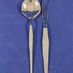 May include: A silver spoon and butter knife with a textured pattern on the handles.
