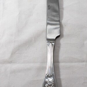 May include: A silver dinner knife with an ornate handle featuring a bird and floral design. The blade is stamped with the word "Spode" and "China".