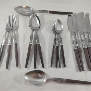 May include: A set of silverware with brown wooden handles. The set includes knives, forks, spoons, and a serving spoon.