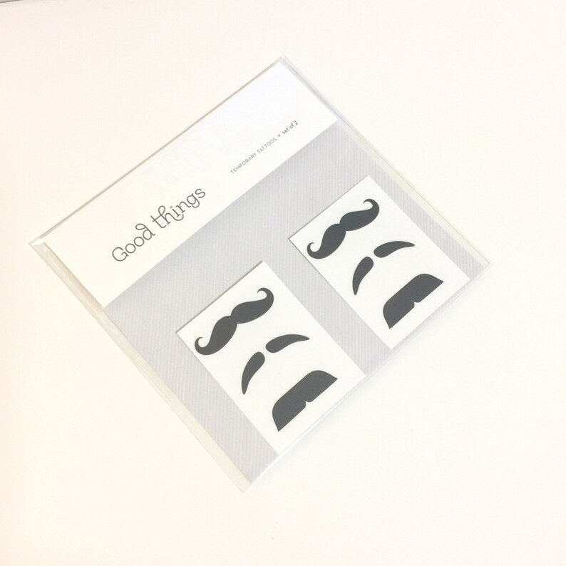 2-sheet set of finger mustache temporary tattoos featuring 6 unique black mustache styles including handlebar, chevron, and pencil stache designs. Hilarious and fun fake tattoos perfect for photo booths, parties, Halloween, Movember, gag gifts, or bachelorette fun. A bestselling classic that brings instant laughs. Easy to apply, safe on skin, and sized to sit right above your finger for that perfect faux-stache moment.