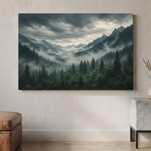 Può includere: Una stampa artistica rettangolare da parete che raffigura un paesaggio di pini verde scuro che coprono il fondovalle, con cime montuose frastagliate che si ergono sullo sfondo sotto un cielo pesante, coperto e nuvoloso pieno di nebbia.