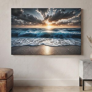 Può includere: Una stampa artistica rettangolare da parete che raffigura un tramonto sull'oceano. La scena presenta nuvole scure e drammatiche con raggi di sole che filtrano, illuminando le onde turchesi mentre si infrangono su una spiaggia sabbiosa.