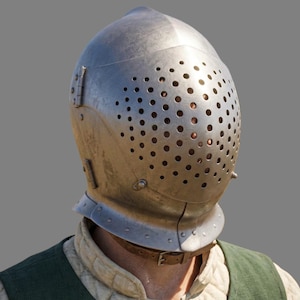 May include: A metallic silver-colored knight helmet featuring a rounded dome and a hinged visor with numerous circular ventilation holes. The helmet is secured with a brown leather chin strap and is worn over a quilted beige garment and green vest.