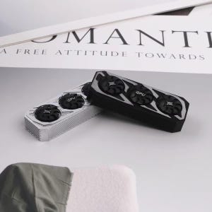 May include: Two rectangular GPU cooling fan units, one in a metallic silver finish and one in a matte black finish. Each unit features three circular black fans with the text GPU printed on the centre of the middle fan, and a textured side casing.