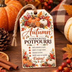 May include: A rectangular paper tag with a jute string featuring the text Autumn Simmering Potpourri and instructions to add contents to a pot with 2-3 cups of water, simmer on low, and refill as needed. The tag is decorated with pumpkins, orange slices, cinnamon sticks, and autumn leaves.