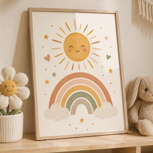 Peut inclure: Une affiche encadrée représentant un soleil jaune souriant avec des rayons, un arc-en-ciel multicolore dans des tons orange, jaune et vert, et deux nuages à la base. L'illustration comprend de petites étoiles et des cœurs aux tons doux sur un fond crème.