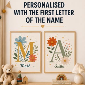 Op de afbeelding: Twee rechthoekige wandposters in lichte houten lijsten met de letters M en A, versierd met bloemillustraties en de namen Maël en Adèle. De tekst erboven luidt: PERSONALISED WITH THE FIRST LETTER OF THE NAME.