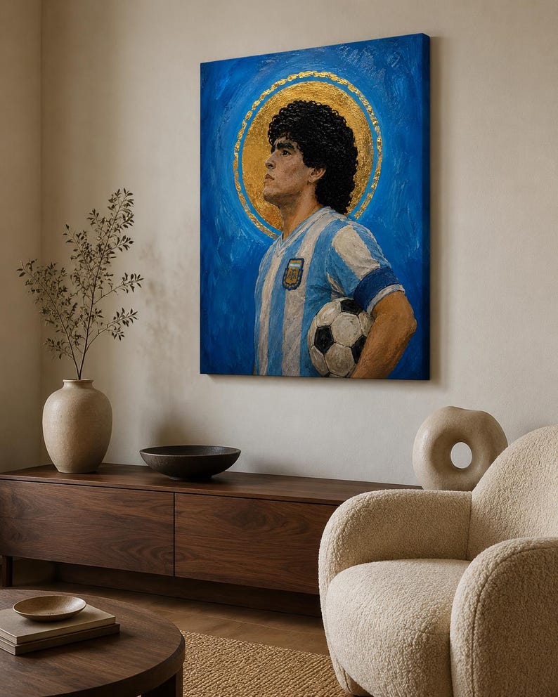 May include: A rectangular canvas wall art piece featuring an oil painting of a soccer player with dark curly hair, wearing a light blue and white striped jersey, holding a soccer ball, set against a vibrant blue background with a gold halo.
