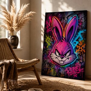 Peut inclure: Une impression d'art mural rectangulaire repr&eacute;sentant une illustration de style graffiti vibrante d'une t&ecirc;te de lapin rose et violette avec des contours n&eacute;on lumineux. Le fond est une surface sombre et textur&eacute;e couverte de graffitis.