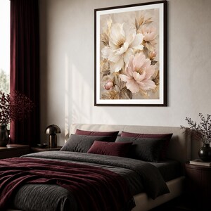 May include: A framed wall art print featuring a botanical illustration of large, layered white and soft pink peony flowers with golden-toned foliage accents, set against a neutral, textured beige background within a dark brown frame.