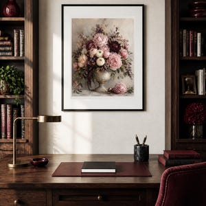 May include: A framed wall art print featuring a detailed floral arrangement of pink, white, and deep burgundy peonies and greenery in a classic pedestal vase, with a single loose peony blossom resting on the surface below the vase.