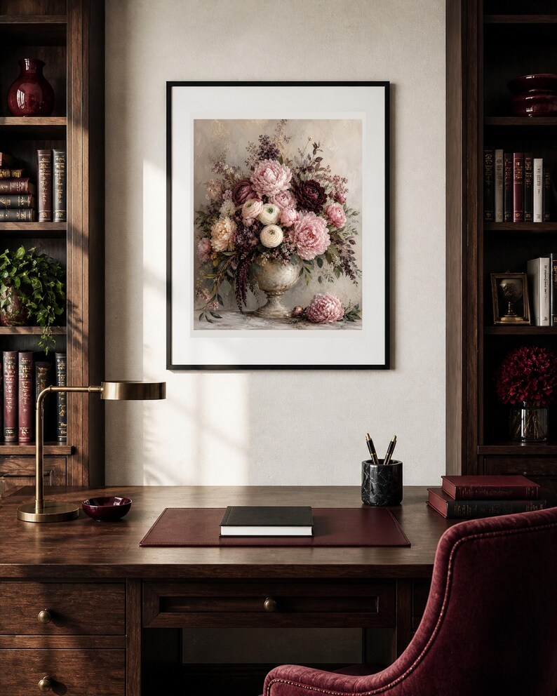 May include: A framed wall art print featuring a detailed floral arrangement of pink, white, and deep burgundy peonies and greenery in a classic pedestal vase, with a single loose peony blossom resting on the surface below the vase.