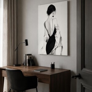 May include: A rectangular wall art print featuring a black and white illustration of a person seen from behind, wearing a black dress with thin straps and a loose, light-colored draped garment over their shoulders, with dark hair in a bun.