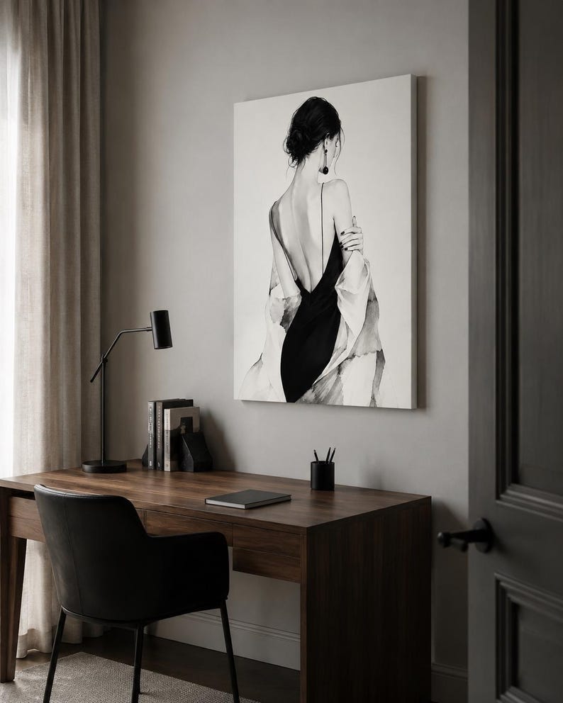 May include: A rectangular wall art print featuring a black and white illustration of a person seen from behind, wearing a black dress with thin straps and a loose, light-colored draped garment over their shoulders, with dark hair in a bun.