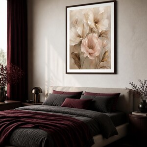 May include: A framed wall art print featuring a botanical illustration of large, layered flowers in shades of cream, beige, and soft pink. The artwork displays delicate petals and slender stems against a neutral, muted background, enclosed in a dark frame.