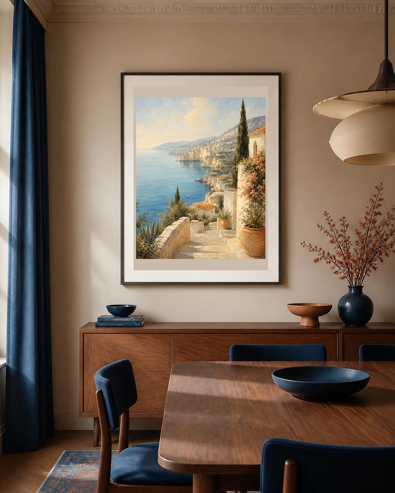 Puede incluir: Una impresi&oacute;n art&iacute;stica enmarcada que representa un paisaje costero mediterr&aacute;neo con una escalera de piedra que conduce hacia un mar azul, edificios con techos de terracota, cipreses y plantas en macetas bajo un cielo soleado.