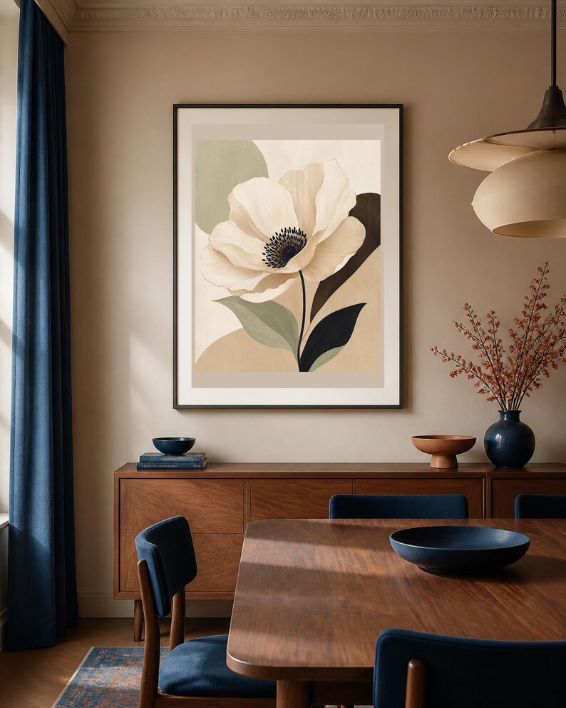 K&ouml;nnte beinhalten: Ein gerahmter Kunstdruck mit einer gro&szlig;en, cremefarbenen Blume mit dunkler Mitte vor einem Hintergrund aus abstrakten Formen in Beige, Salbeigr&uuml;n und Dunkelbraun. Das Kunstwerk befindet sich in einem d&uuml;nnen schwarzen Rahmen an einer beigen Wand.