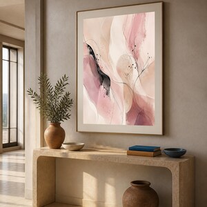 K&ouml;nnte beinhalten: Ein gerahmter vertikaler Wandkunstdruck mit abstrakten Aquarellformen in Altrosa, zartem Rosa und Creme, akzentuiert durch feine schwarze Tintenlinien und zarte botanische Skizzen, eingefasst in einem d&uuml;nnen, goldfarbenen Metallrahmen.