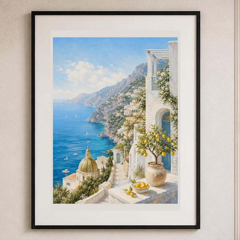 May include: A framed wall art print depicting a coastal Mediterranean landscape with a blue sea, a domed church, and a white building with a balcony. A potted lemon tree and a bowl of fresh yellow lemons sit on a stone terrace in the foreground.