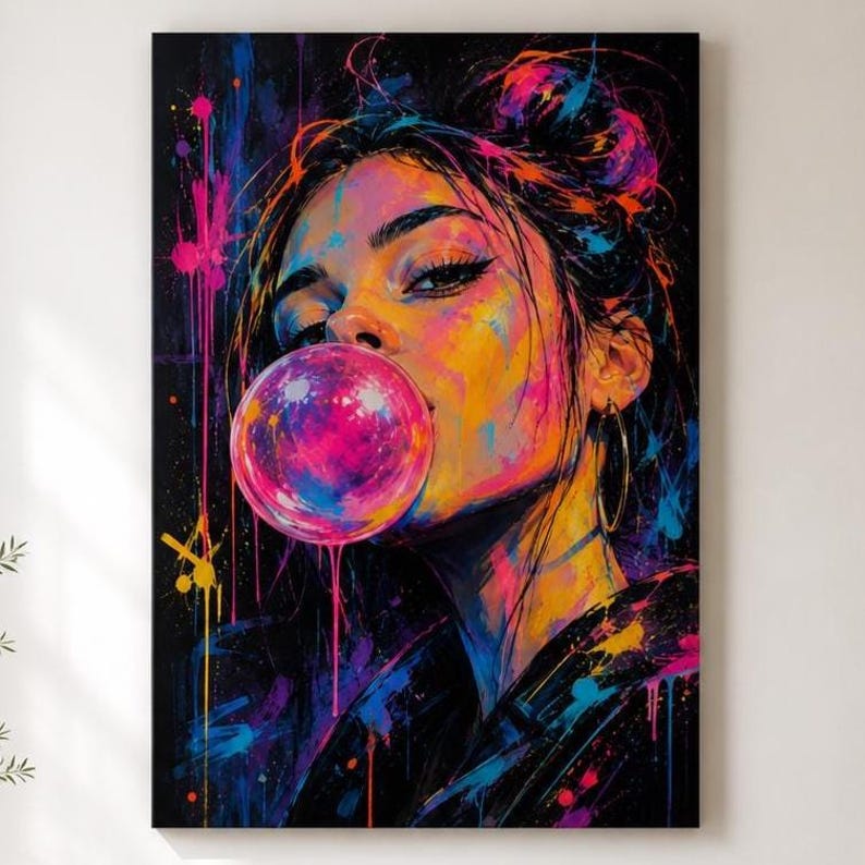 Puede incluir: Una vibrante impresi&oacute;n de arte mural que muestra el retrato de una persona con cabello oscuro en un mo&ntilde;o desordenado, soplando una gran burbuja de chicle rosa brillante. La obra utiliza un estilo graffiti con salpicaduras de pintura ne&oacute;n amarilla, azul y rosa.