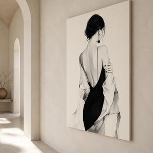 May include: A large rectangular wall art print featuring a black and white illustration of a person seen from behind. The figure wears a black slip dress with thin straps and a draped light-colored garment over their shoulders, with dark hair in a bun.