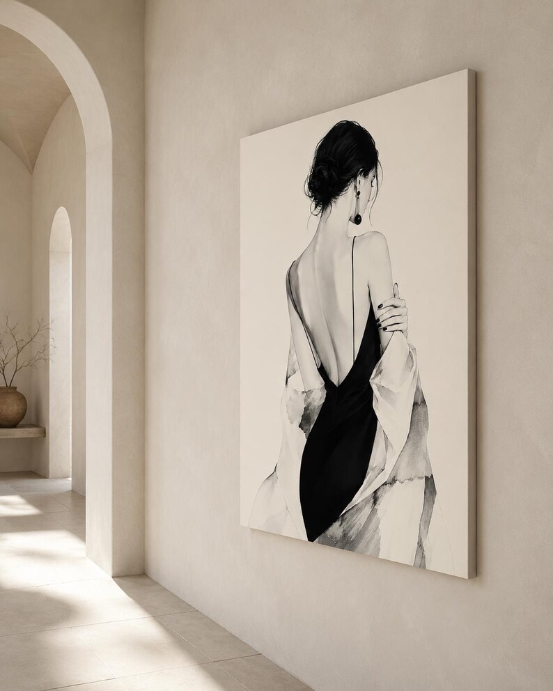 May include: A large rectangular wall art print featuring a black and white illustration of a person seen from behind. The figure wears a black slip dress with thin straps and a draped light-colored garment over their shoulders, with dark hair in a bun.