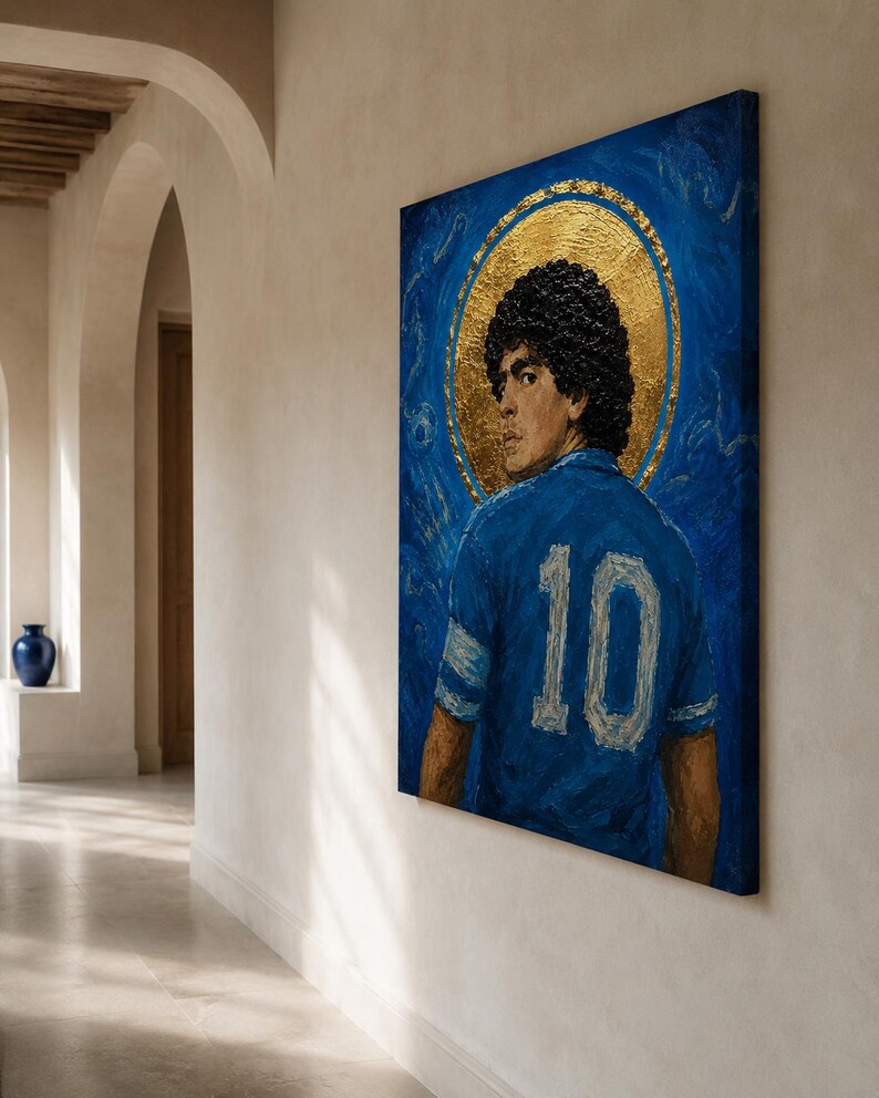 May include: A rectangular canvas painting featuring a portrait of a footballer with dark curly hair, wearing a blue jersey with the number 10 in white. The figure is set against a deep blue background with a prominent gold circular halo behind the head.