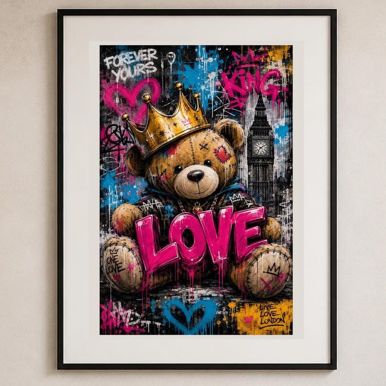 May include: A framed wall art print featuring a brown teddy bear wearing a gold crown, holding a large pink sign that reads LOVE. The background displays graffiti-style street art with splashes of blue and pink, including the text FOREVER YOURS, KING, and a silhouette of Big Ben in London.