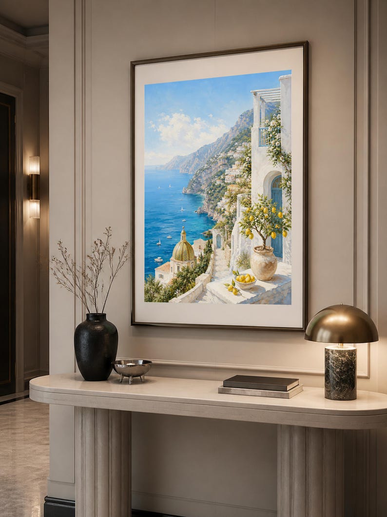 May include: A framed vertical wall art print depicting a coastal Mediterranean scene with a blue sea, a domed church, white buildings, and a potted lemon tree on a terrace. The painting features bright yellow lemons, green foliage, and a clear sky.