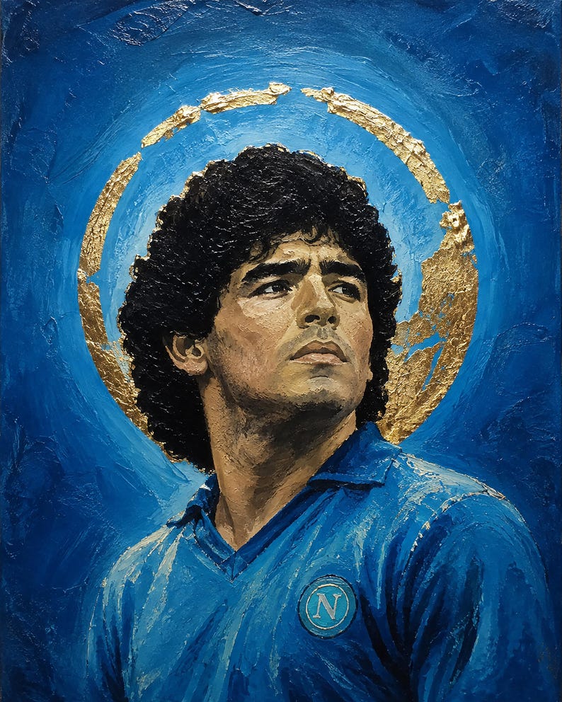 Puede incluir: Una pintura al &oacute;leo sobre lienzo que representa un retrato de Diego Maradona con cabello oscuro rizado, vistiendo una camiseta azul con cuello y un logotipo N circular en el pecho. Un halo de pan de oro texturizado rodea la cabeza sobre un fondo azul.