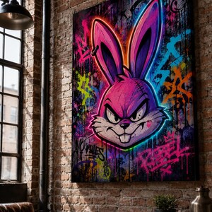 Peut inclure: Une impression murale rectangulaire repr&eacute;sentant une t&ecirc;te de lapin stylis&eacute;e violette et rose avec un contour n&eacute;on. Le fond est une fresque de style graffiti sombre avec des &eacute;claboussures vives de peinture bleue, orange et jaune, incluant le texte NO RULES et REBEL.